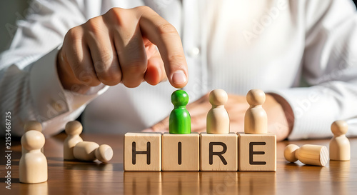 Recruiter choosing a green wooden figure from a group for hiring and talent acquisition.