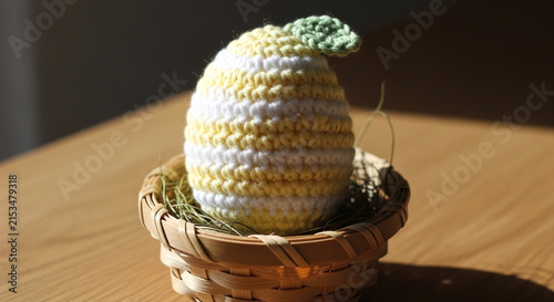 Crocheted lemon fruit toy in a small wicker basket on a wooden table