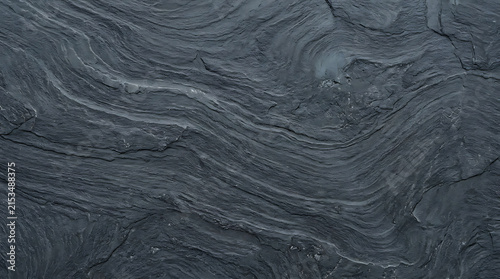 Close-up of layered dark gray slate surface with textured natural rock patterns and subtle striations for geological and