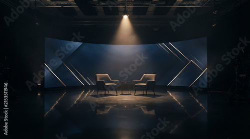 Two modern armchairs face each other in a dimly lit, minimalist studio setting.