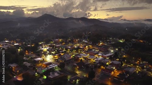 Franklin main street lined with illuminated restaurants, souvenir stores, and mountain lodges. North Carolina travel destination at night.