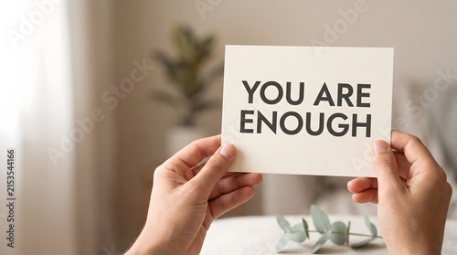 Mental health awareness showing hands holding you are enough affirmation card for psychological wellbeing support