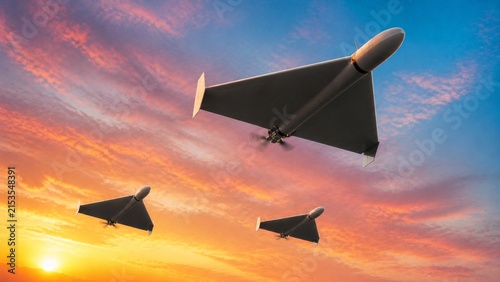 Three delta-wing military drones flying in formation at sunset
