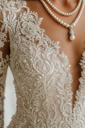 ivory V-neck bridal gown with intricate beaded lace appliqués and pearl embellishments paired with a layered pearl necklace