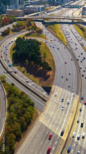 Wide highway cutting through Atlanta city center with steady traffic flow and modern urban architecture.