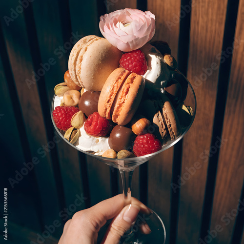 Elegant Hand-Held Martini Glass Filled with Colorful Macarons and Nuts