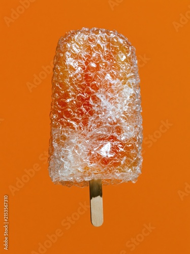 Bubble Wrap Ice Pop with Crushed Air Cells on Vivid Orange Background