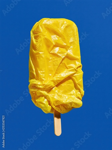 Yellow Rubber Glove Ice Pop with Textured Folded Fingers on Cobalt Blue Background