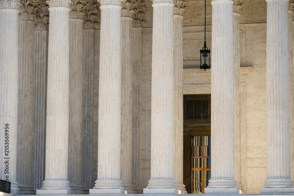 Fototapeta premium Supreme Court columns symbolize authority. Classical facade with massive pillars. Government building with timeless architecture. Court house exterior with elegant columns.