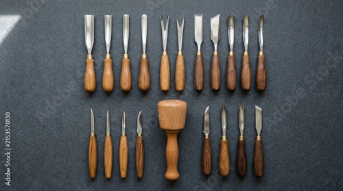 Set of professional wood carving chisels and wooden mallet on dark background.