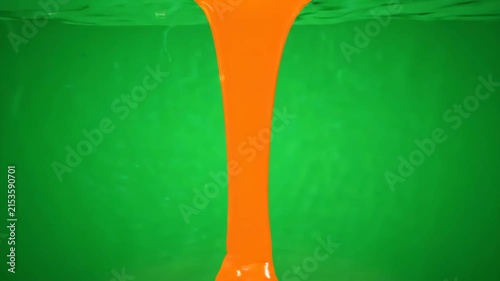 Abstract background featuring a stream of orange liquid flowing through a vibrant green fluid.