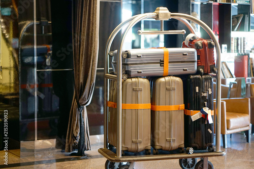 Canvas Print Luggage cart holds multiple suitcases in elegant hotel lobby