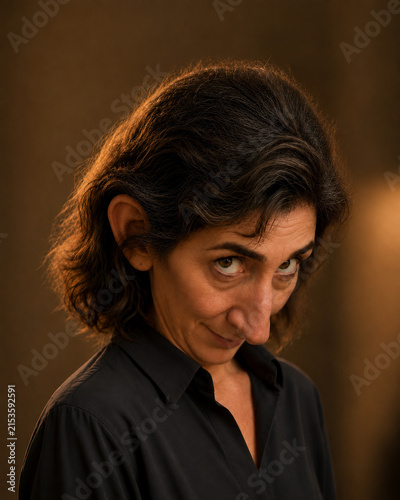 Woman tilting her head down while looking upward with sly smile