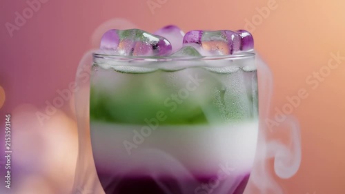 A colorful layered cocktail with dry ice smoke effect for a creative molecular mixology presentation.