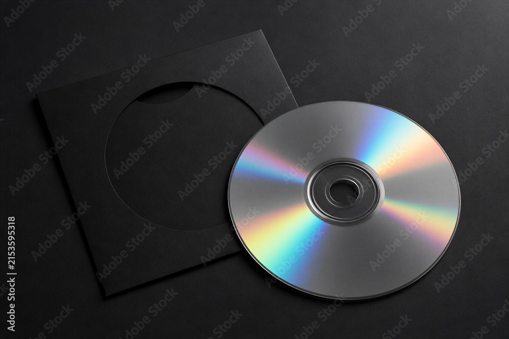Fototapeta premium Silver disk next to black sleeve on dark gray surface