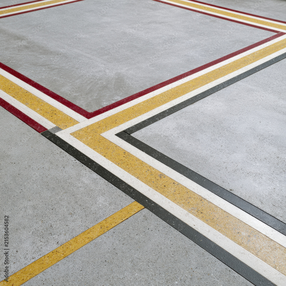 Fototapeta premium Geometric Concrete Floor with Red Yellow and Black Linear Inlays