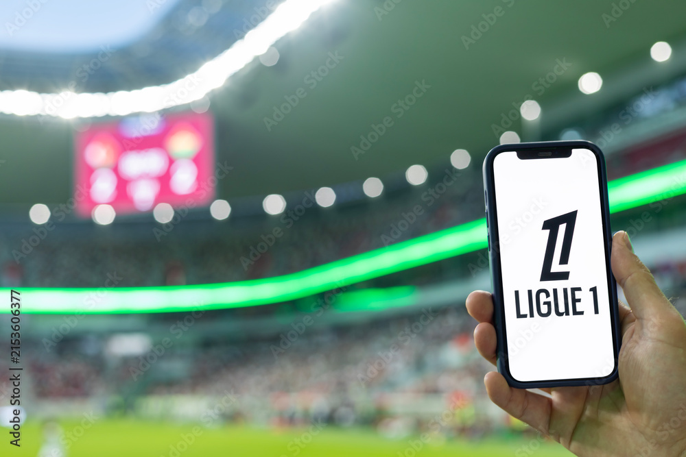 Fototapeta premium MINSK, BELARUS JUNE 9, 2026: Man holding Apple iPhone 12 in the stadium. The official logo of the France national football championship