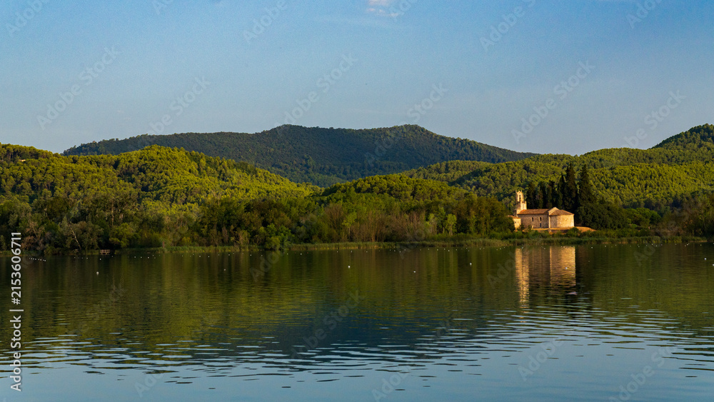 Fototapeta premium Historic Stone Church Reflected in Calm Lake at Sunset