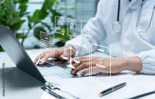 Healthcare professional reviews digital compliance documents on laptop, illustrating medical regulation, legal standards, certification, policy verification, quality assurance, and clinical governance
