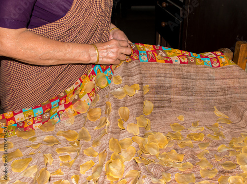 Obraz na płótnie Elderly Indian housewife in saree performing daily household chores making potato chips at home, domestic life, homemaking and everyday family responsibilities