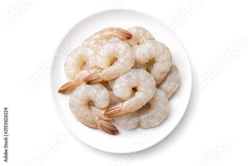 Pile of raw peeled shrimp on white plate isolated on white background