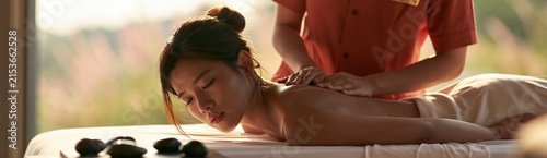 Calm spa massage closeup of a reclining woman receiving shoulder treatment for wellness poster and relaxation background