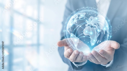 Businessman holding glowing digital globe with world map and network connections representing global communication, internet and international business.