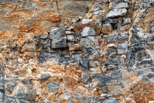 Detailed Texture of Fractured Grey Sedimentary Rock Face with Mineral Veins
