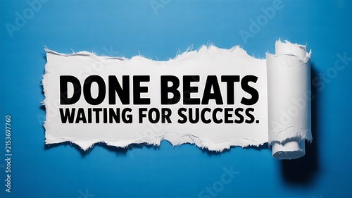 A torn blue paper revealing text that says done beats waiting for success