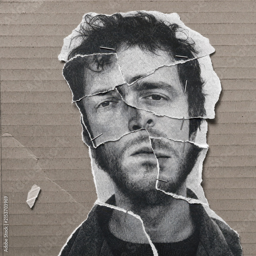 Torn black and white portrait of a man on cardboard background.