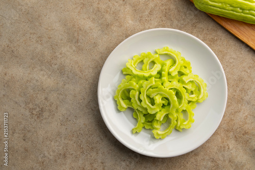 Sliced Bitter Gourd (Bitter Melon) in white plate.Top view.copy space.