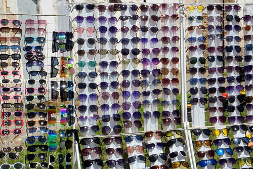 Cuadro en lienzo There is a stand on the street with many different sunglasses.