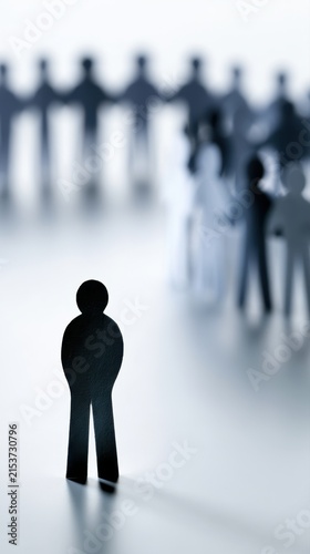 Conceptual image of social isolation showing a solitary figure separated from blurred groups of people in the background symbolizing loneliness and exclusion