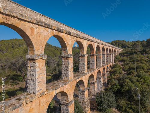 Fotografía Two-tiered Roman aqueduct Pont del Diable near Tarragona, Spain, with sunlit san