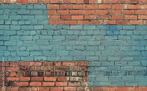 Photography Old rustic red brick wall partially painted with light blue color blocks, abstra