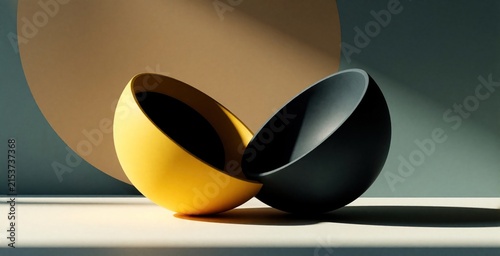 Abstract yellow and black hemispheres rest on table. Geometric shapes form backdrop with soft shadows. Minimalist forms create visual balance and contrast.