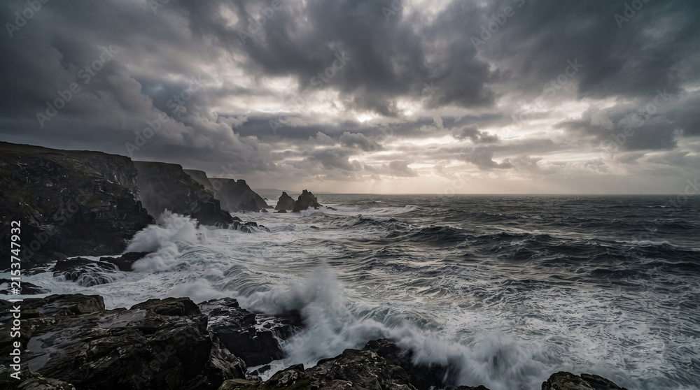 Fototapeta premium Dramatic Storm Clouds Over a Rocky Ocean Coast at Sunset
