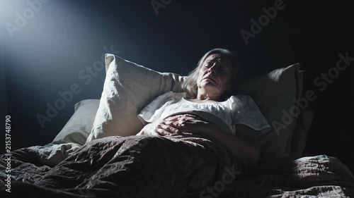 Elderly Woman Suffering From Insomnia And Headache In Bed At Night
