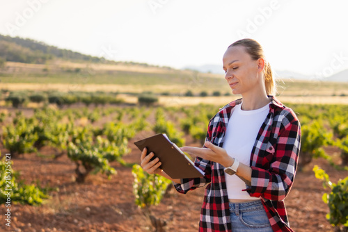 Canvastavla Woman winemaker carefully inspecting grapevines in a sunny vineyard