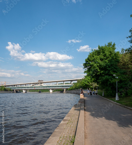 View of Moscow River embankment and metro bridge near Luzhniki Stadium, urban landscape with architecture and clear sky