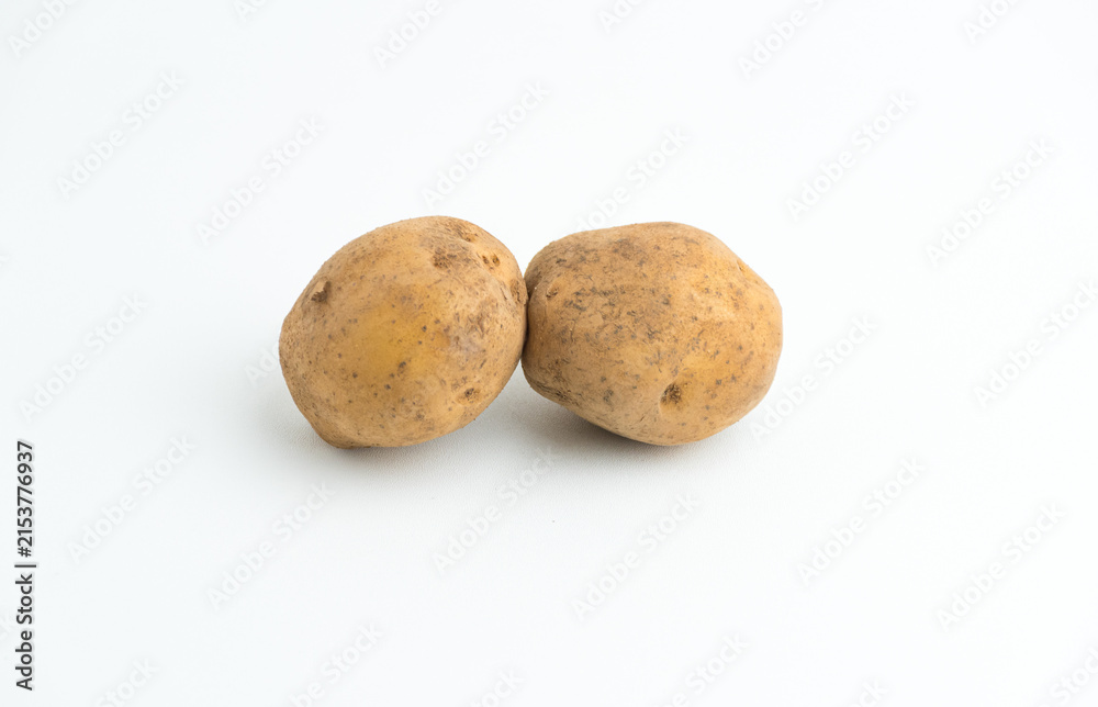Fototapeta premium Two fresh raw brown baby potatoes isolated on a clean white background
