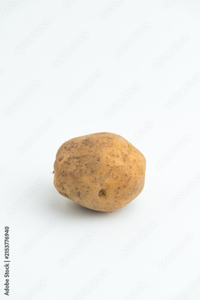 Fototapeta premium Single fresh raw brown baby potato isolated on a white background