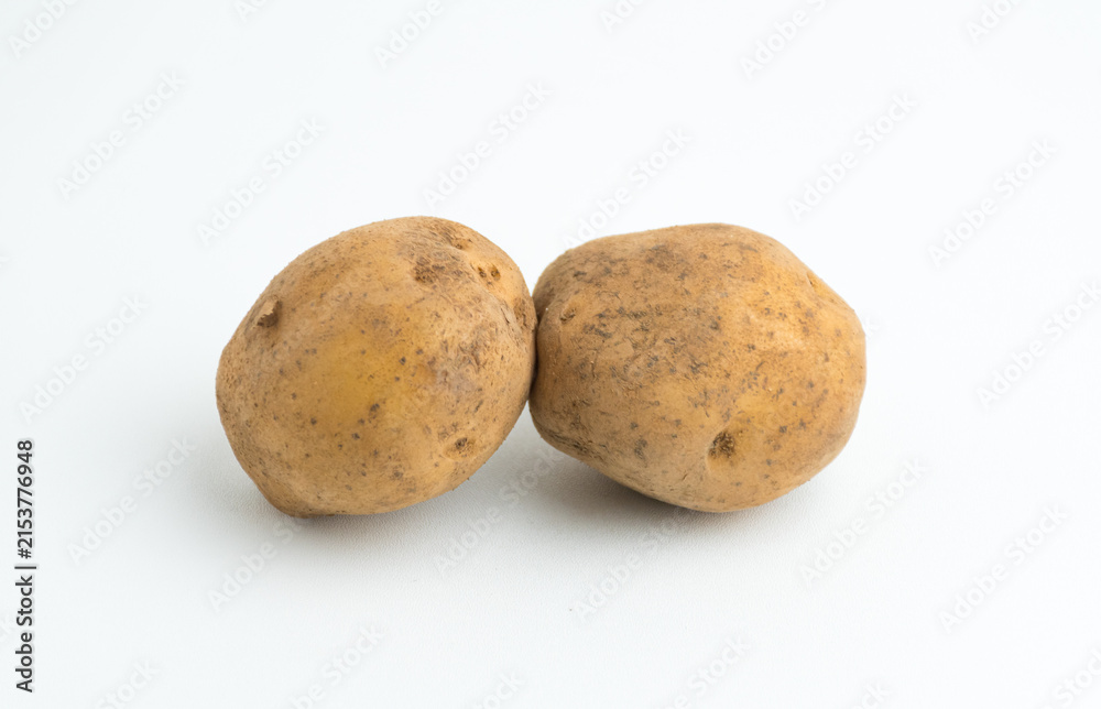 Fototapeta premium Two fresh raw brown baby potatoes isolated on a clean white background