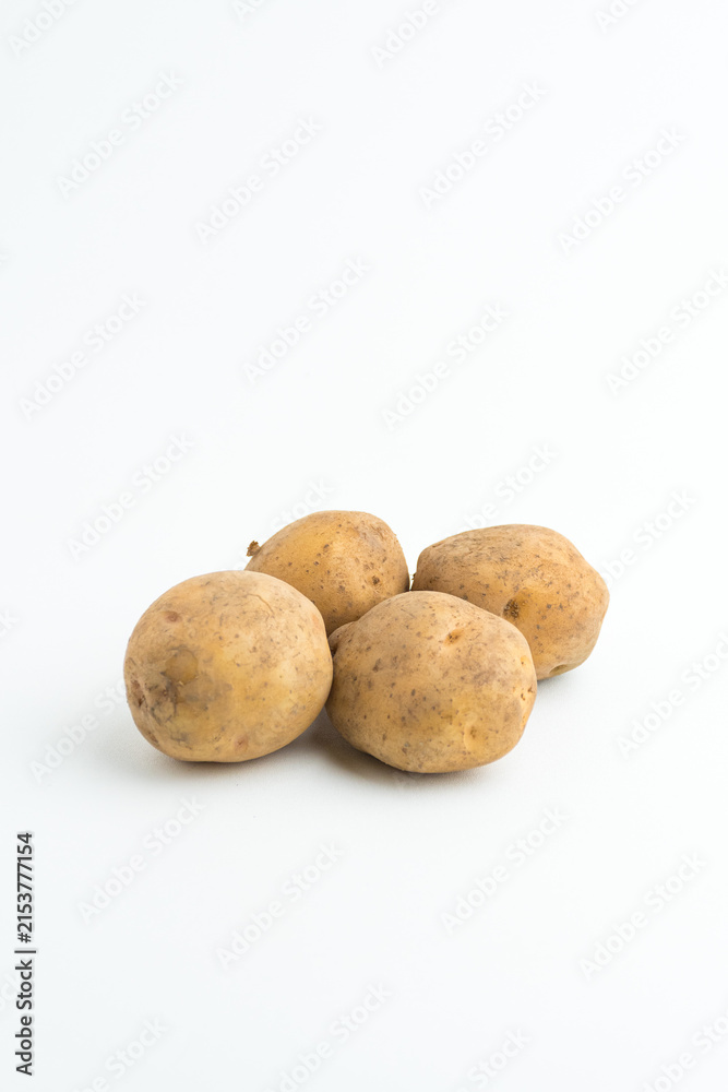 Fototapeta premium Small pile of fresh raw brown baby potatoes isolated on white background