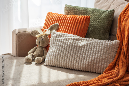 Cozy Autumn Living Room Scene With Plush Cushions And A Stuffed Rabbit