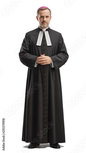 Catholic priest wearing black cassock and clerical collar standing with religion