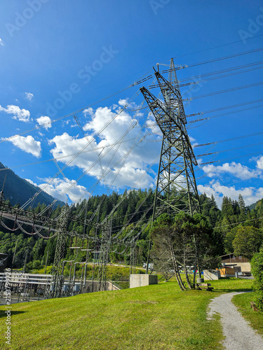 фотографія high voltage power lines and electricity pylon in a scenic alpine mountain lands