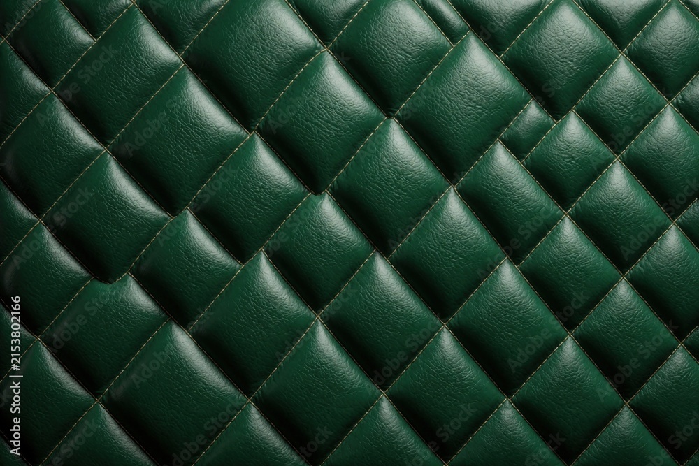 Fototapeta premium Green leather upholstery with diamond quilted pattern. Elegant luxury fabric texture features embossed geometric shapes, neat stitching. Smooth dark emerald material surface for interior design,