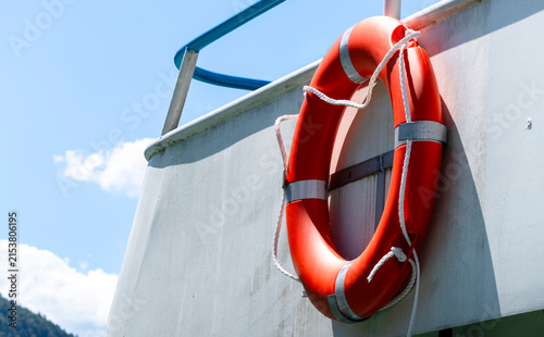 Quadro su tela Bright orange lifebuoy on board a boat, representing water transport and the boating setting in a clean maritime environment