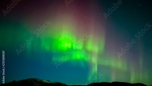 Картината върху платно Northern lights illuminating the night sky over Icelandic landscape